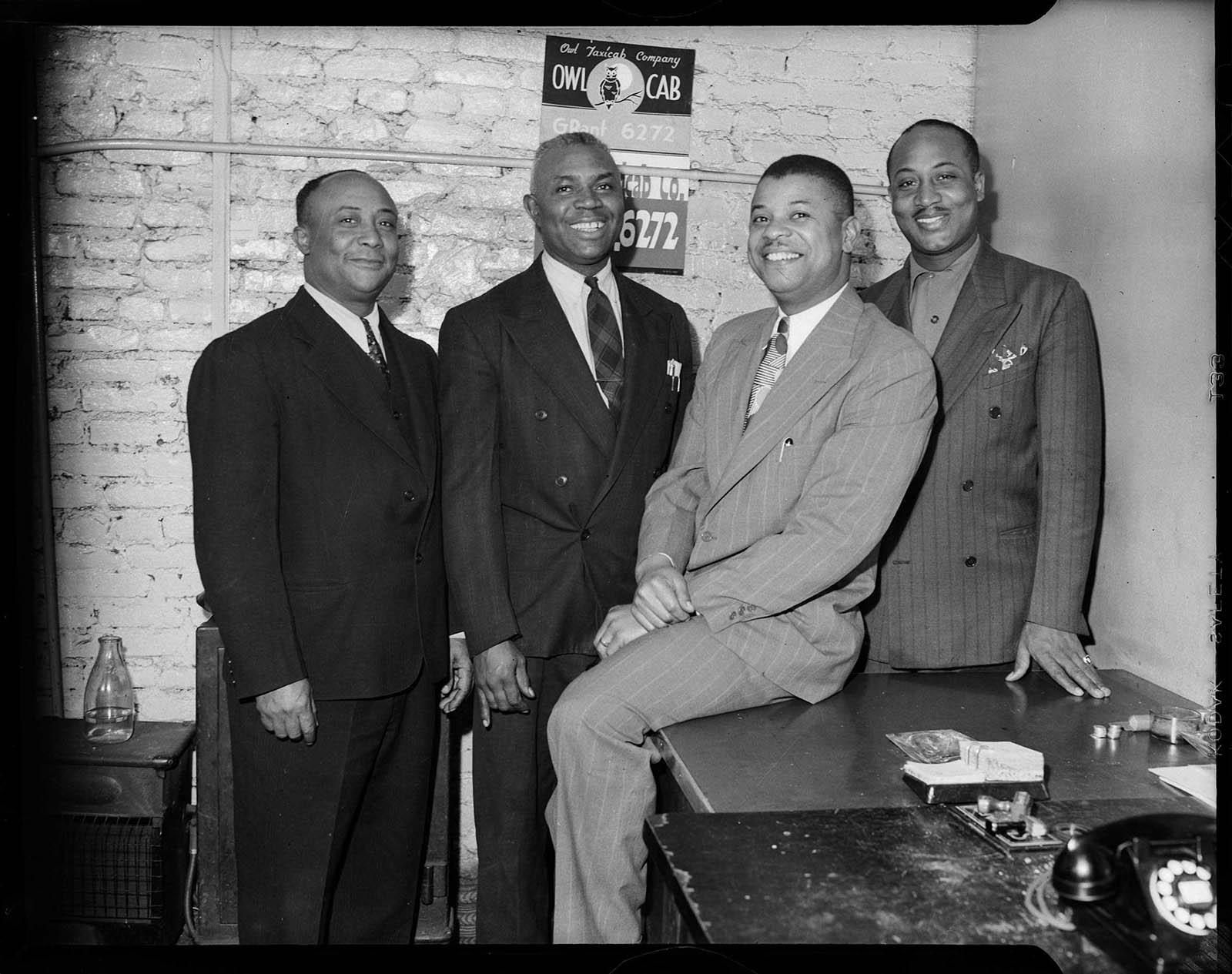 Photograph by Charles Teenie Harris of four men who work for the Owl Taxicab Company