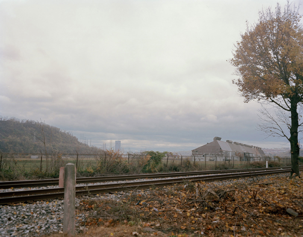 Photograph of railroad with steel plant in the background