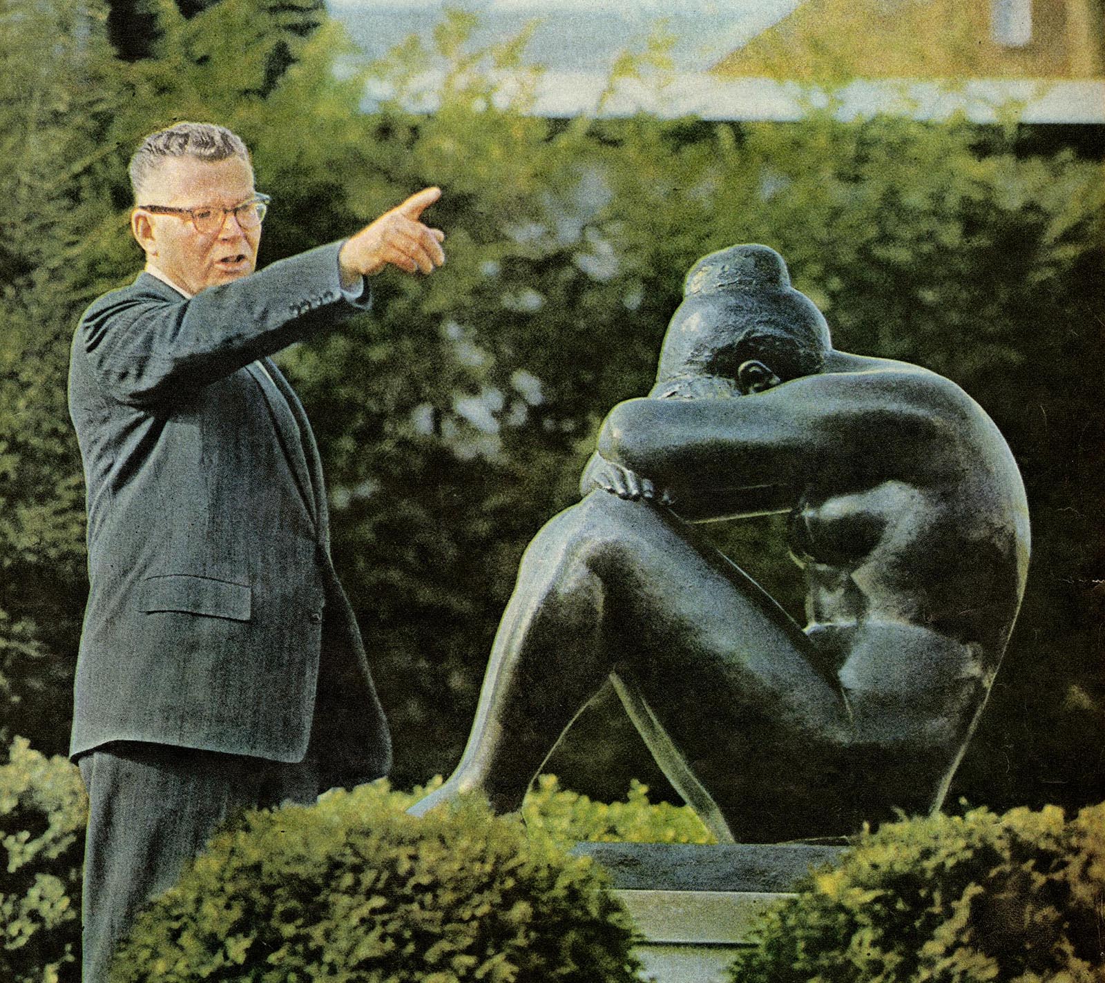 Guy pointing over a statue