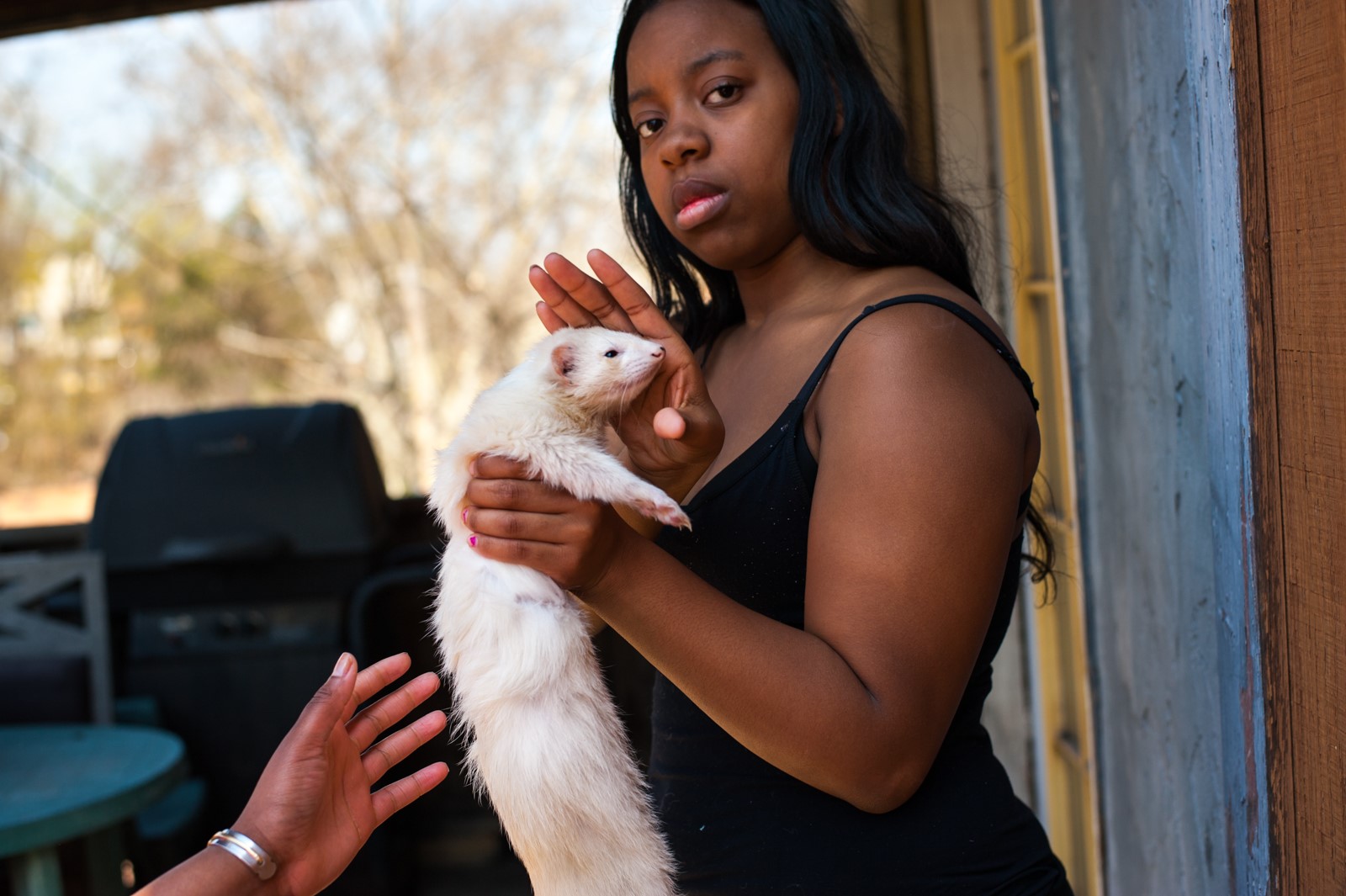 A woman holds her pet ferret.