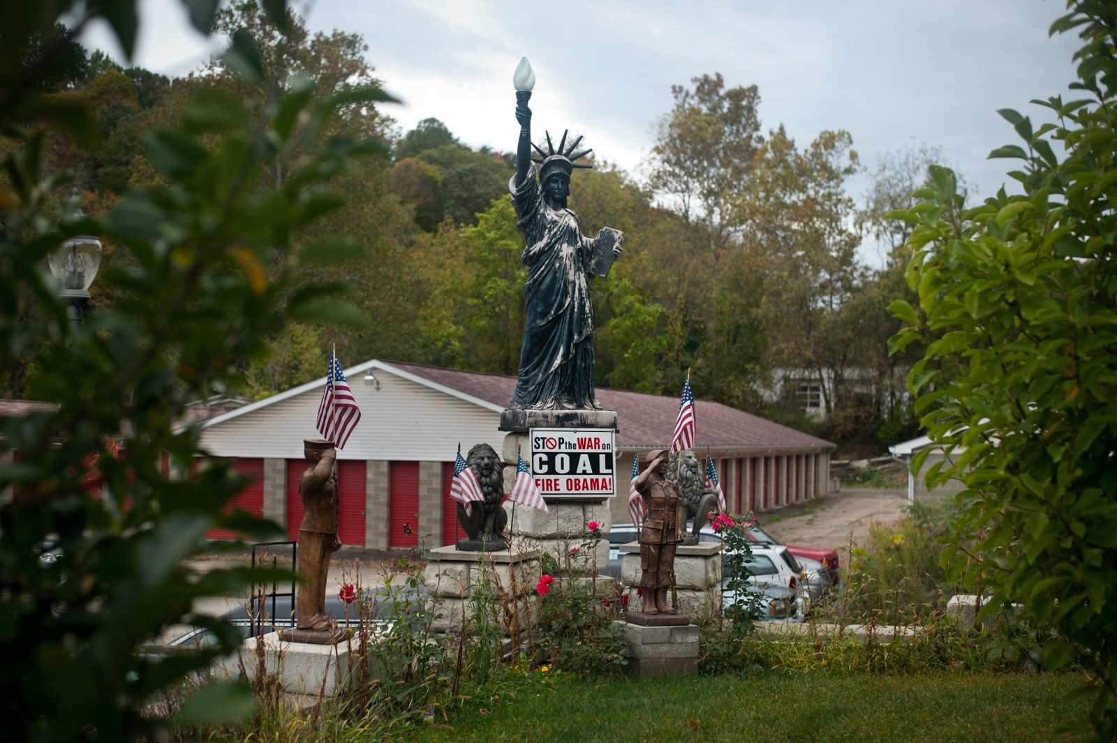 View of different little statues in a yard holding American flags.