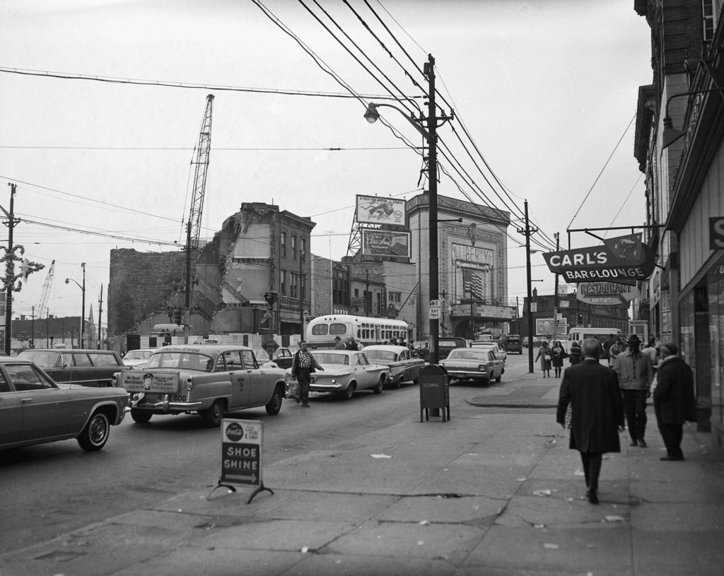 Photograph of an East Liberty street; a building is demolished to the left of frame.