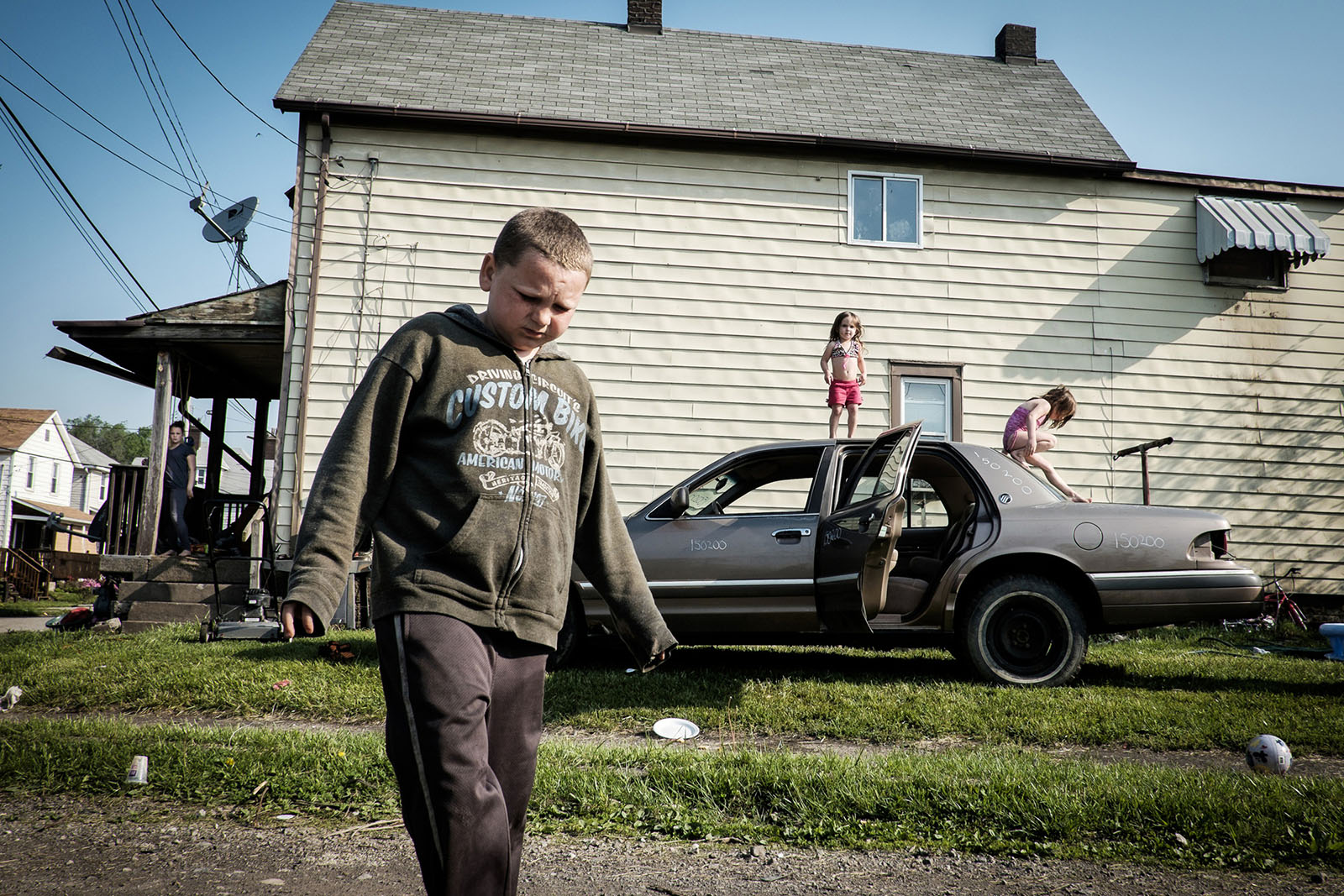 Children play on their dad's demolition derby car outside of their home in West Aliquippa, Pa. USA, on May 8, 2015.