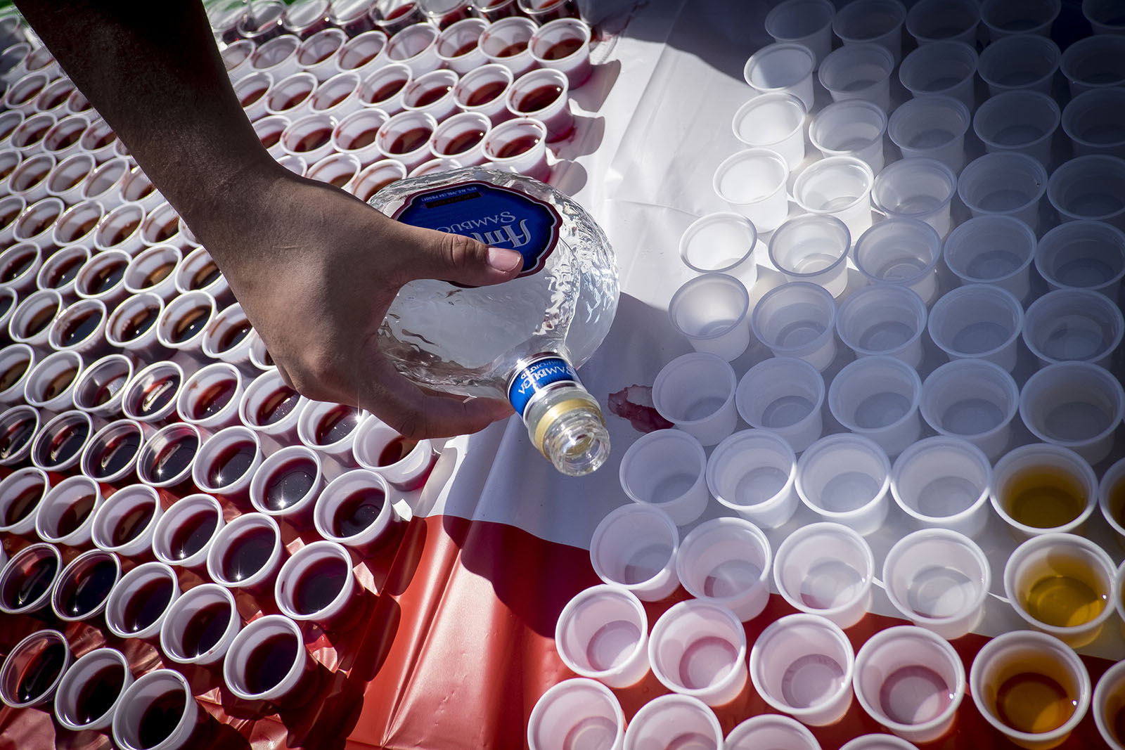 A man pours many shots as part of an Aliquippa festival.