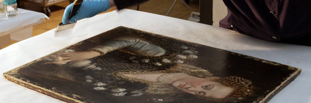 Conservator applies varnish to canvas painting