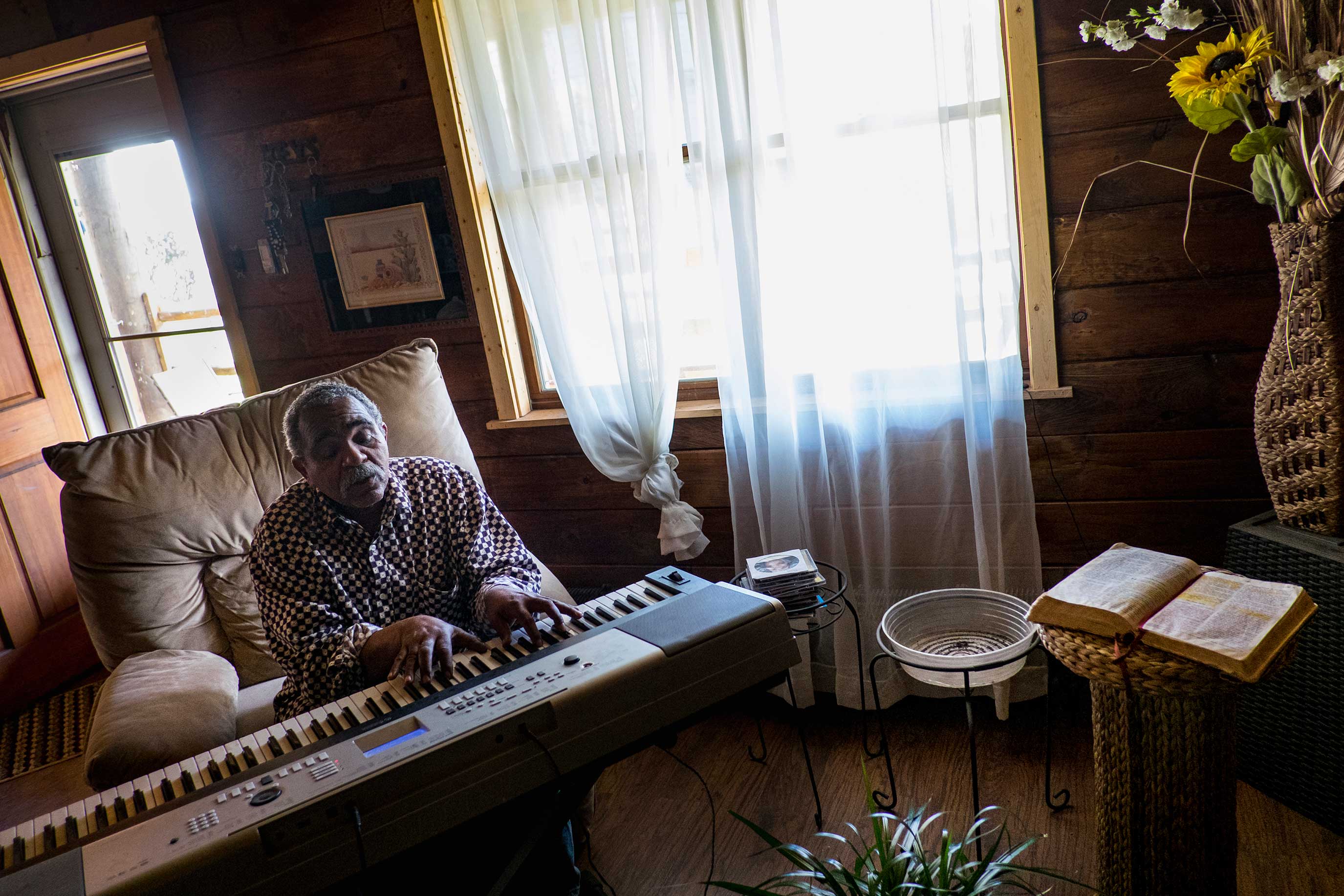 Donald "Amzi" Lightner, 63, plays music in his home in Clairton, Pennsylvania.