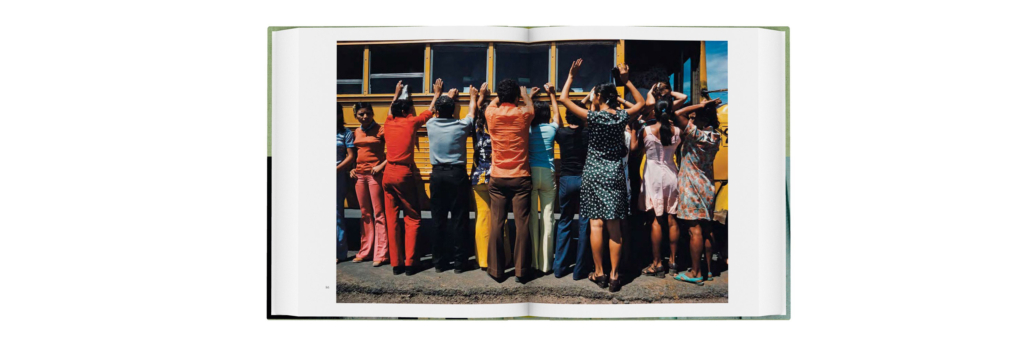 View of an open book, showing an image of people standing, facing away