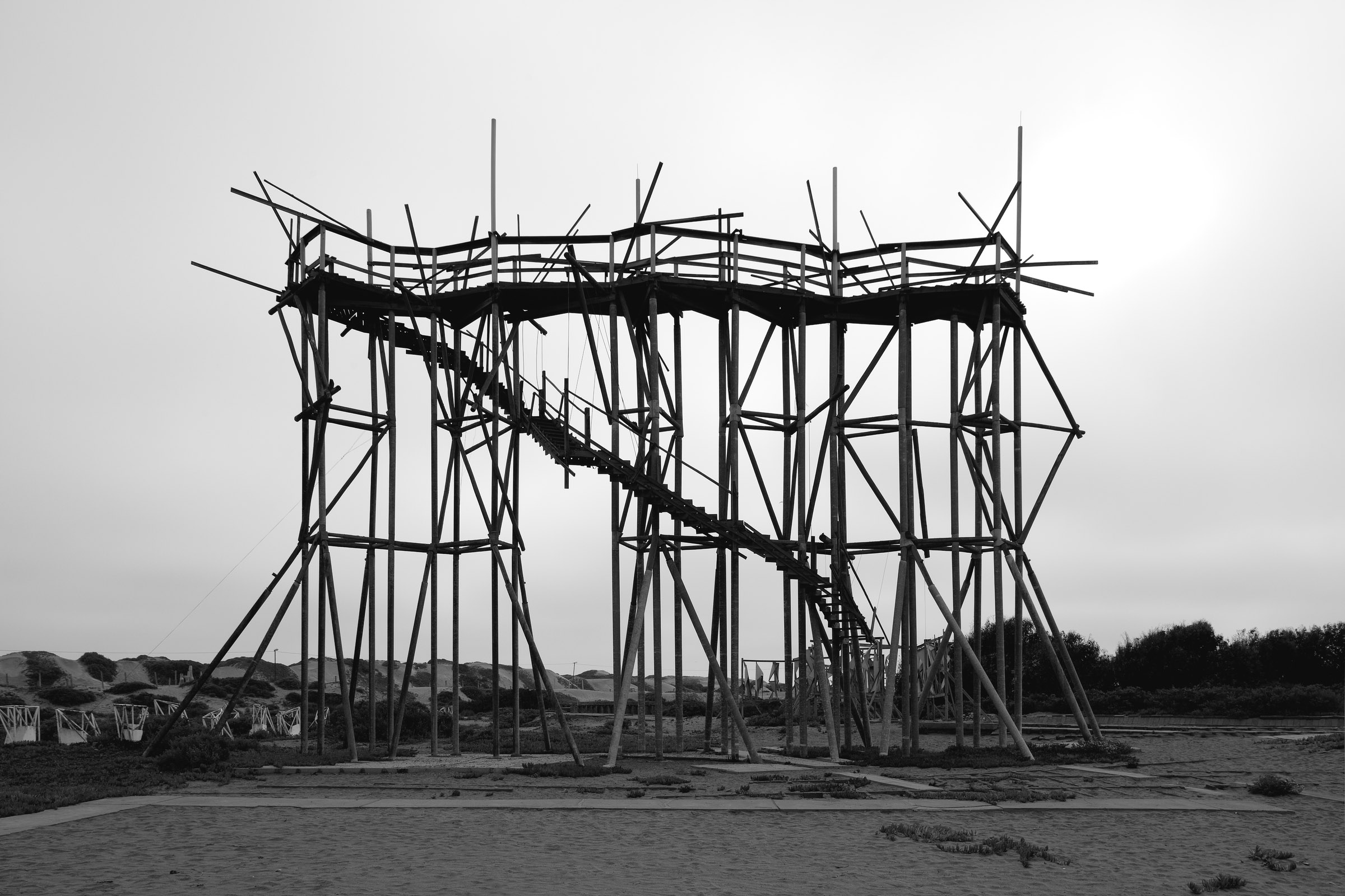 Photograph of geometric stilt structure with staircase leading up the side