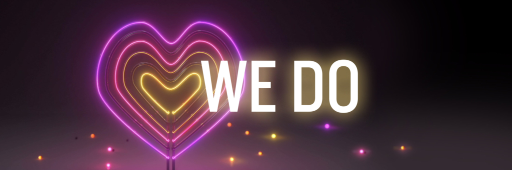 Colorful neon heart on a black background with the text "We Do"