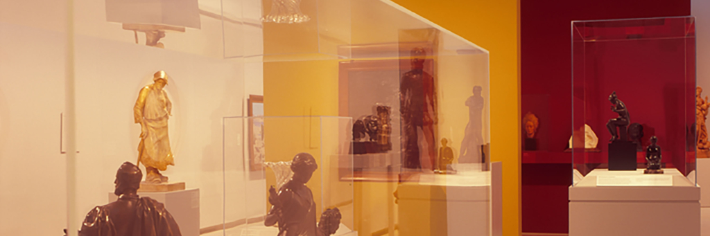 A photograph inside a gallery with sculptures and glass boxes.