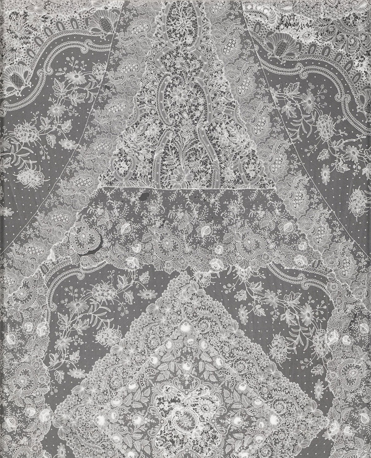 A symmetrical, intricate lace pattern in monochrome shades
