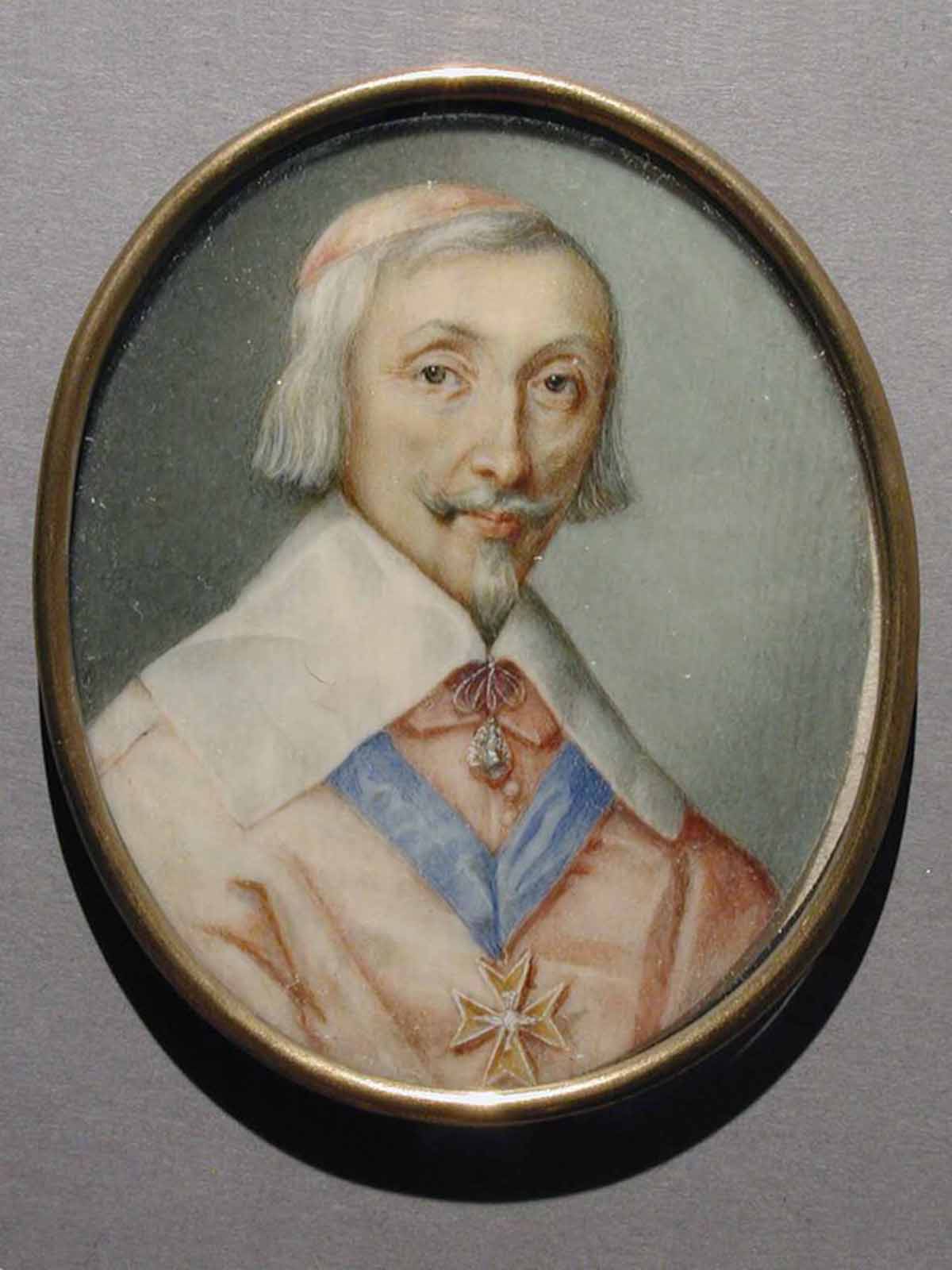 A miniature watercolor portrait of the French Cardinal Richelieu is painted on an oval-shaped piece of ivory with a gold frame.