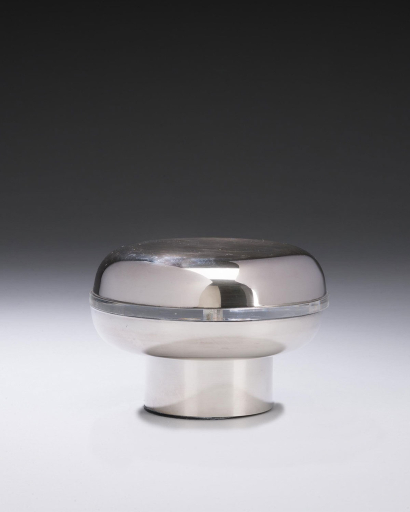 A silver oval sits atop a cylindrical base