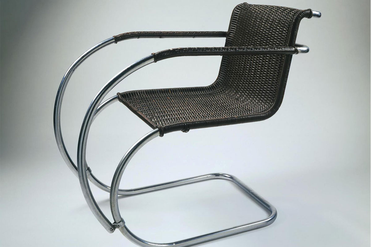 A chair with long, bent, silver arms and legs and a basic black seat