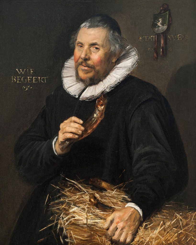 An older man with short, grey hair and a goatee looks knowingly at the viewer; he wears a white ruff collar and dark jacket and holds a red fish in one hand