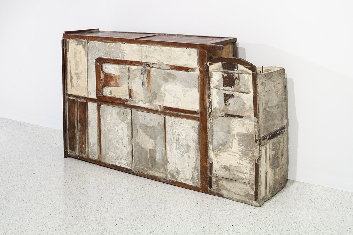 A sculpture made from an armoire covered in cement