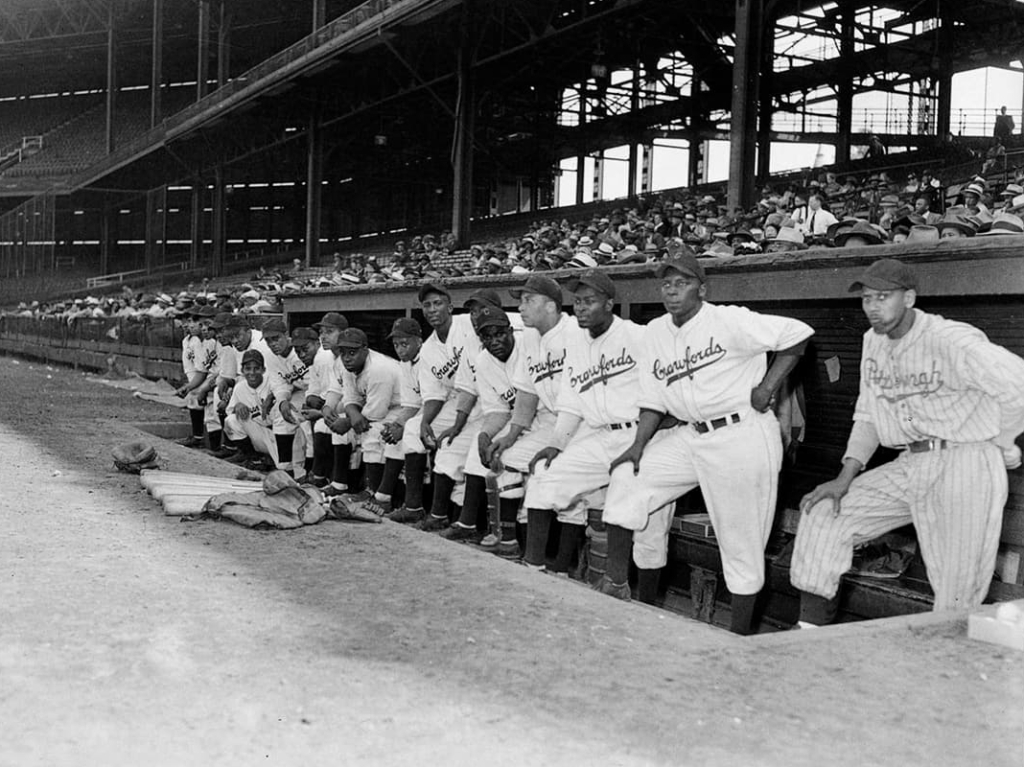 A baseball team stands in a dugout, wearing jerseys labeled "Crawfords"