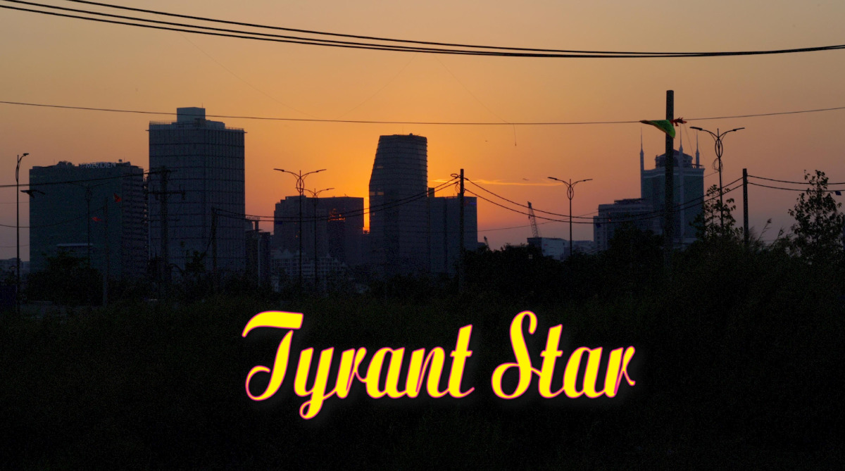 Video still from with title text that reads "Tyrant Star" in script type and overlaying a cityscape at dusk