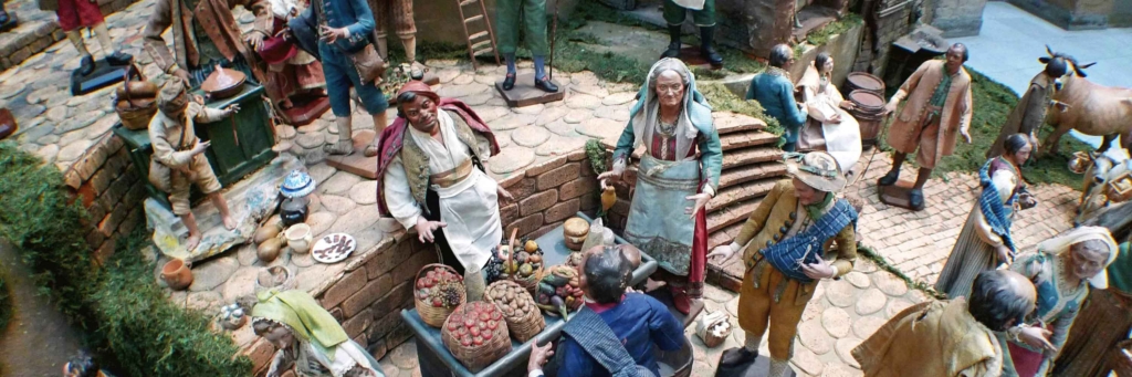 Figures posed in a scene depicting trade in a town square.