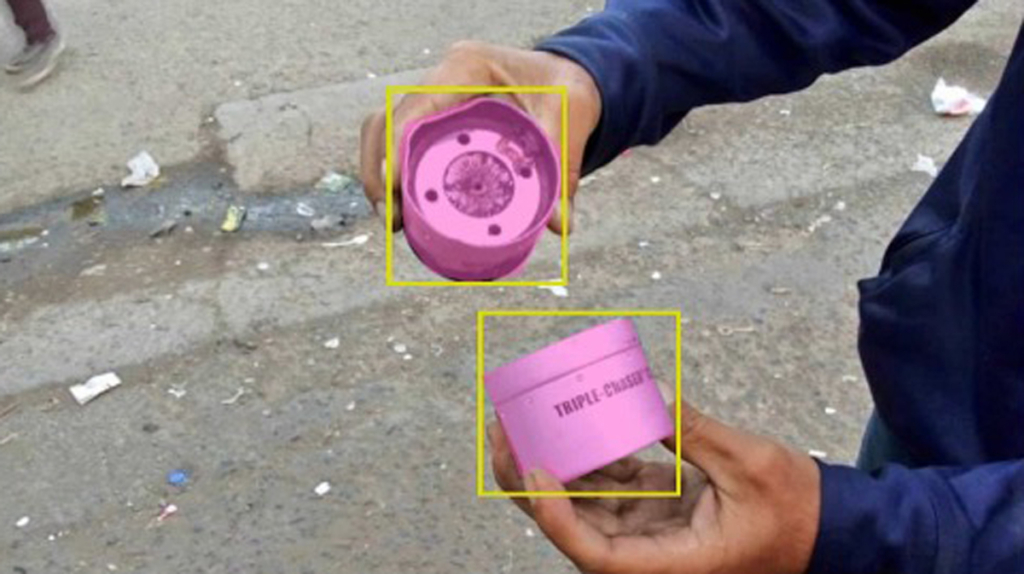 two metal canisters are held by human hands.the objects are framed by squares that imply artificial intelligence software.