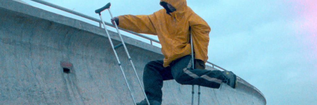 a detail of a film with a man on crutches.