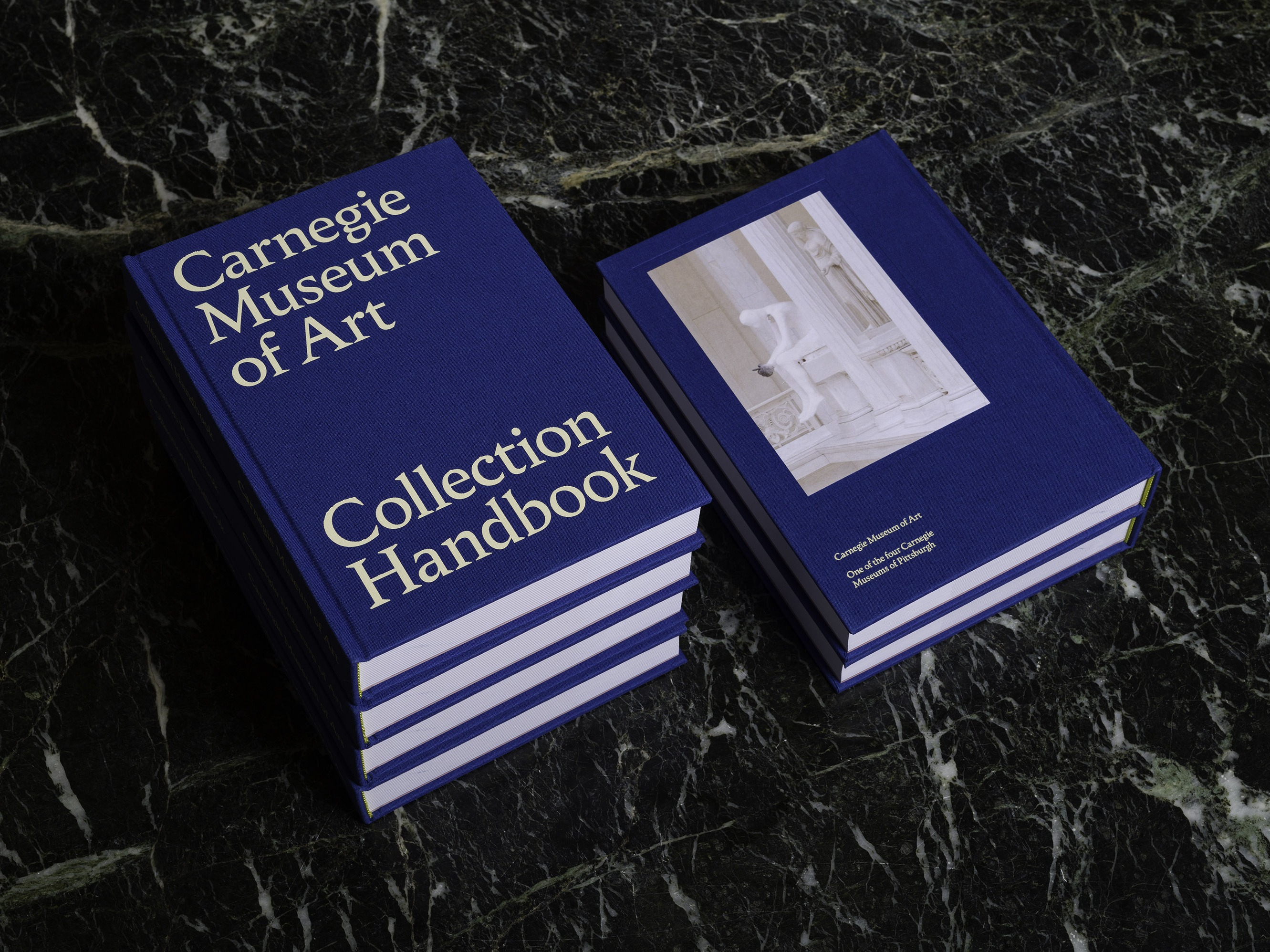 a stack of the carnegie museum of art collection handbook on a marble floor.