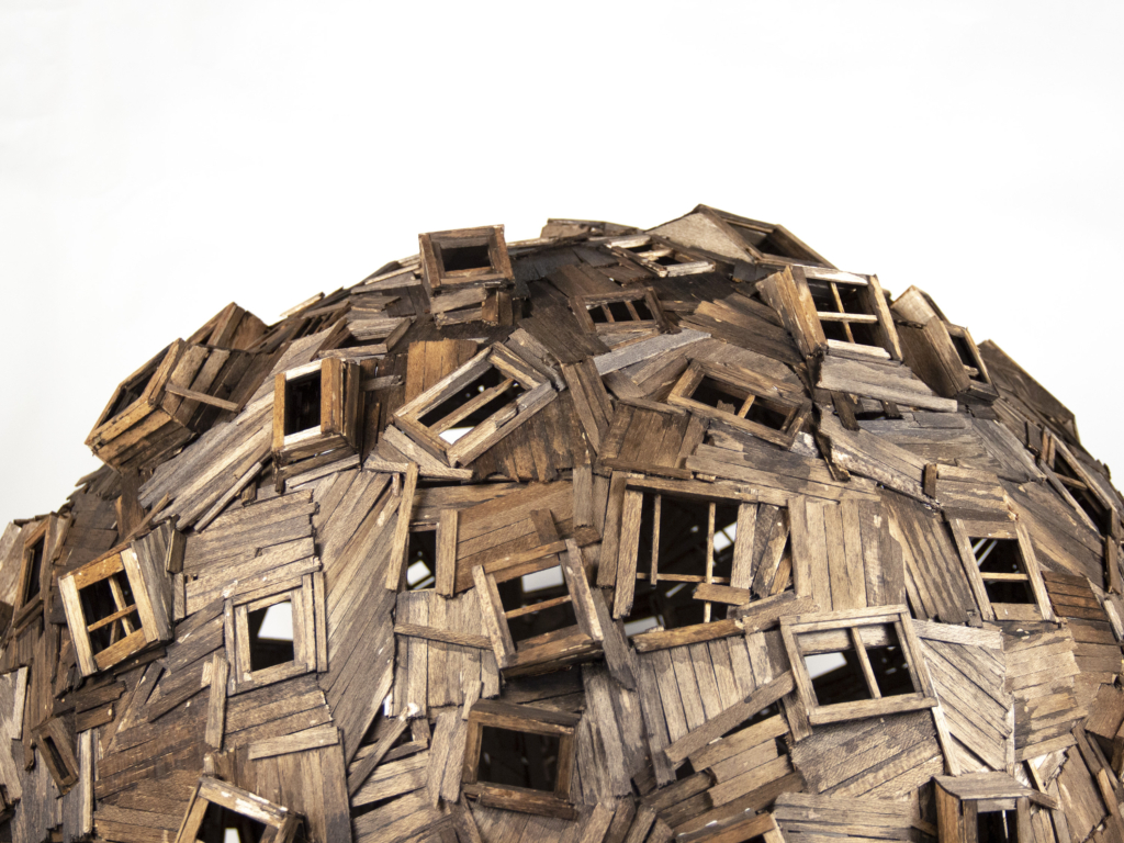 The top of a large sculpture emade out of angular wooden sections, forming the top of a globe