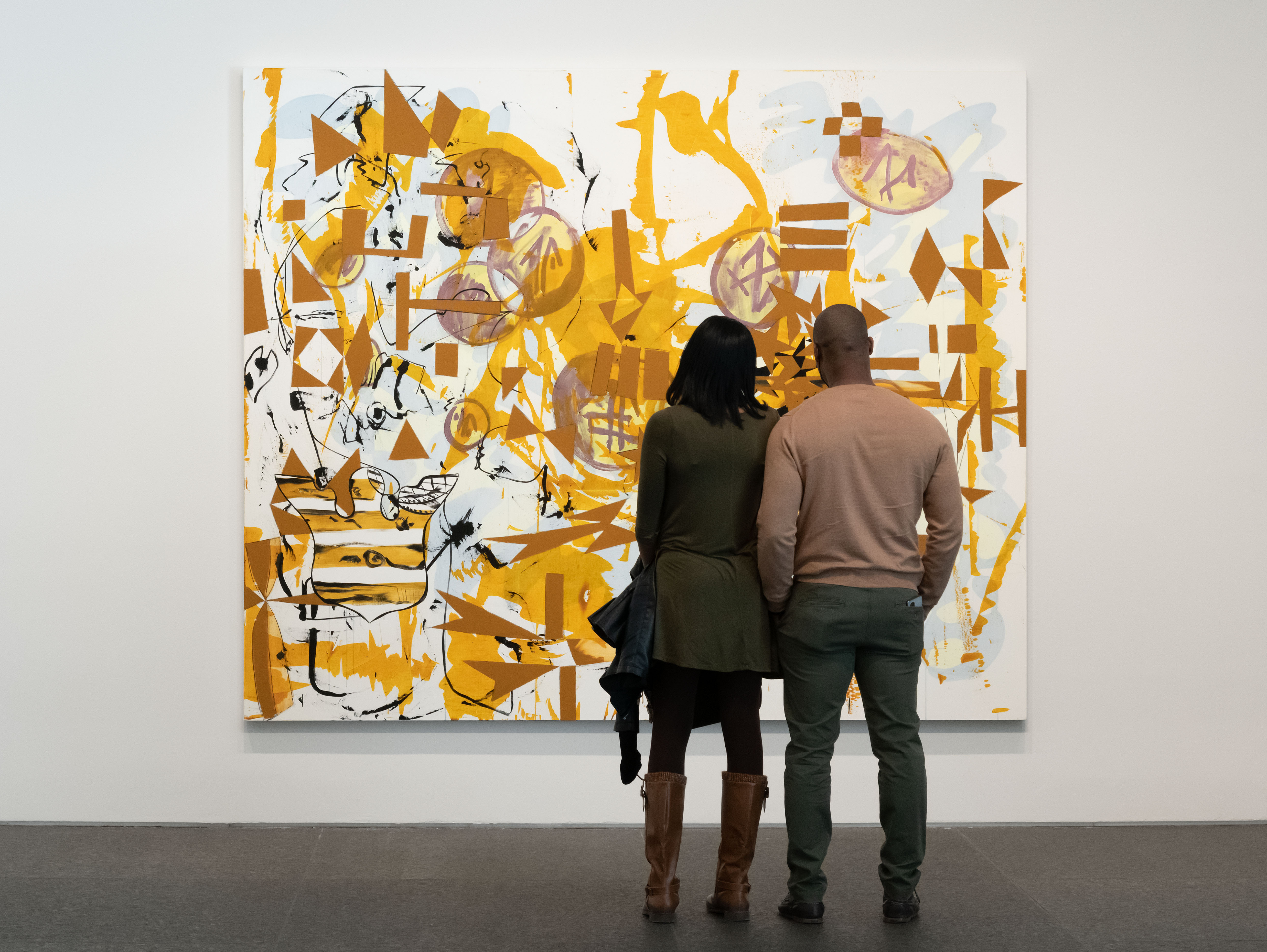 two people standing in front of a painting