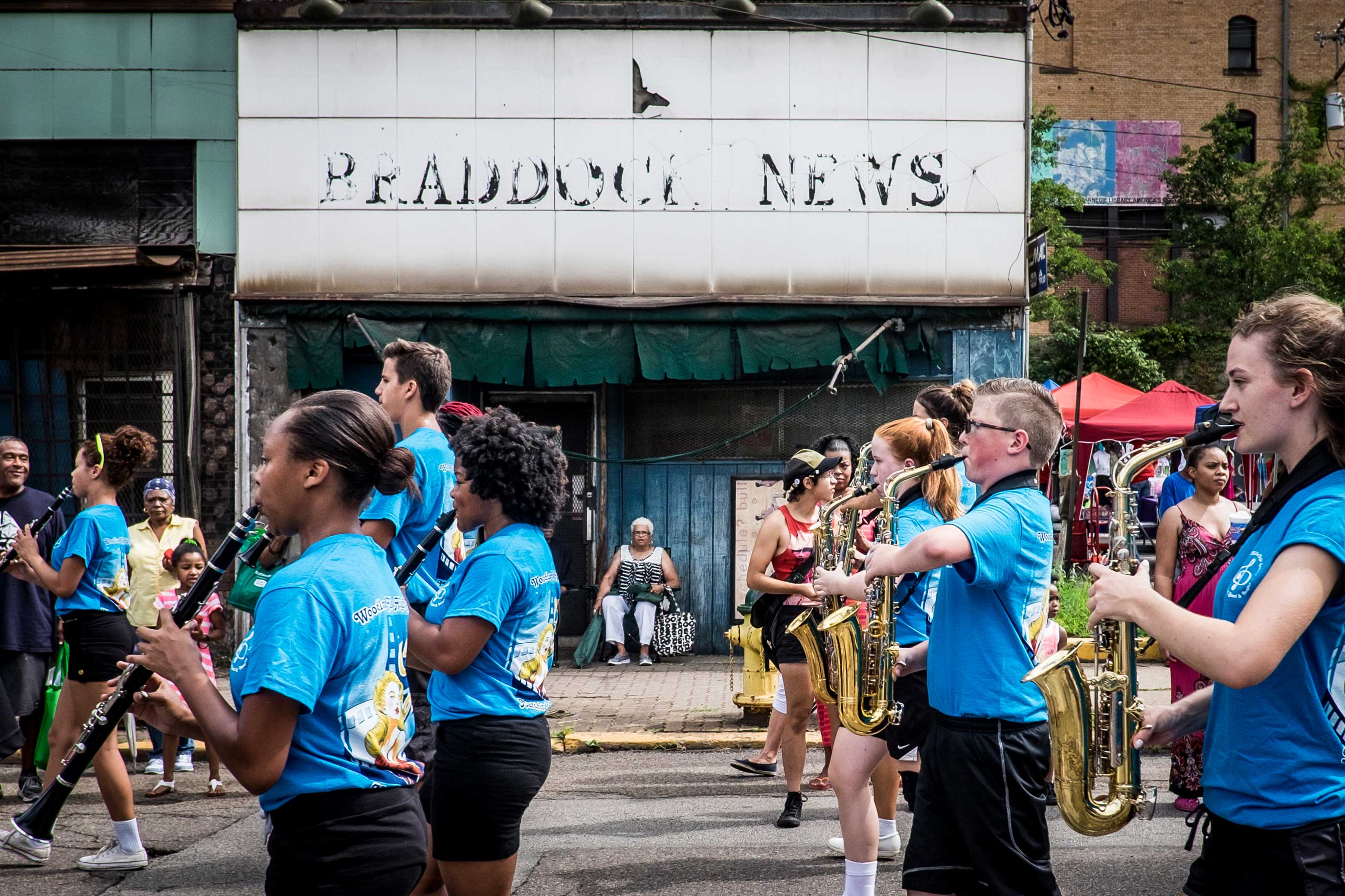 The marching band from nearby Woodland Hills High School passes in front of spectators near the former Braddock News building during the annual Community Day parade in Braddock.