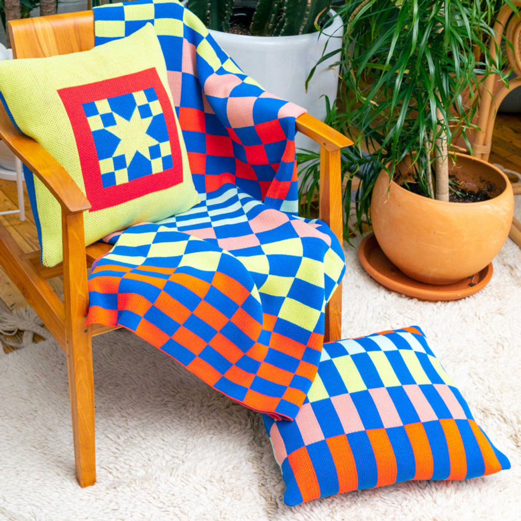 Checkerboard blanket and pillow is draped over a chair