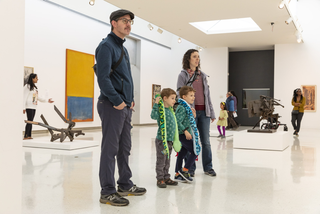 a family in a room with art.