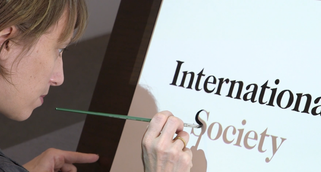 A person painting over the words: International Society