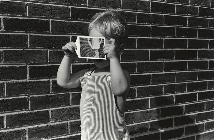 A photo of a boy holding a photo.