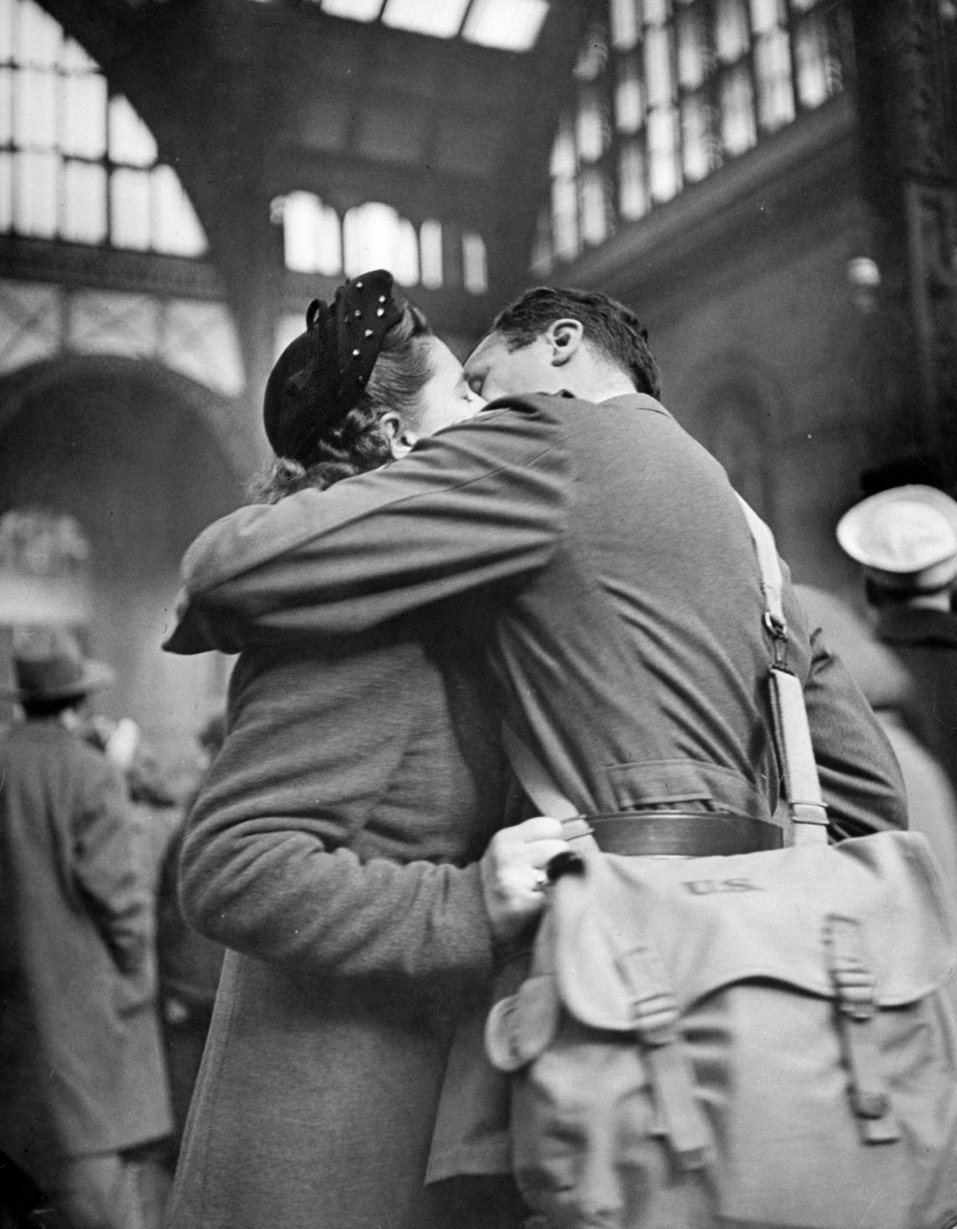 Soldier giving his girlfriend a smothering kiss goodbye at Pennsylvania Station before returning to duty after brief furlough.