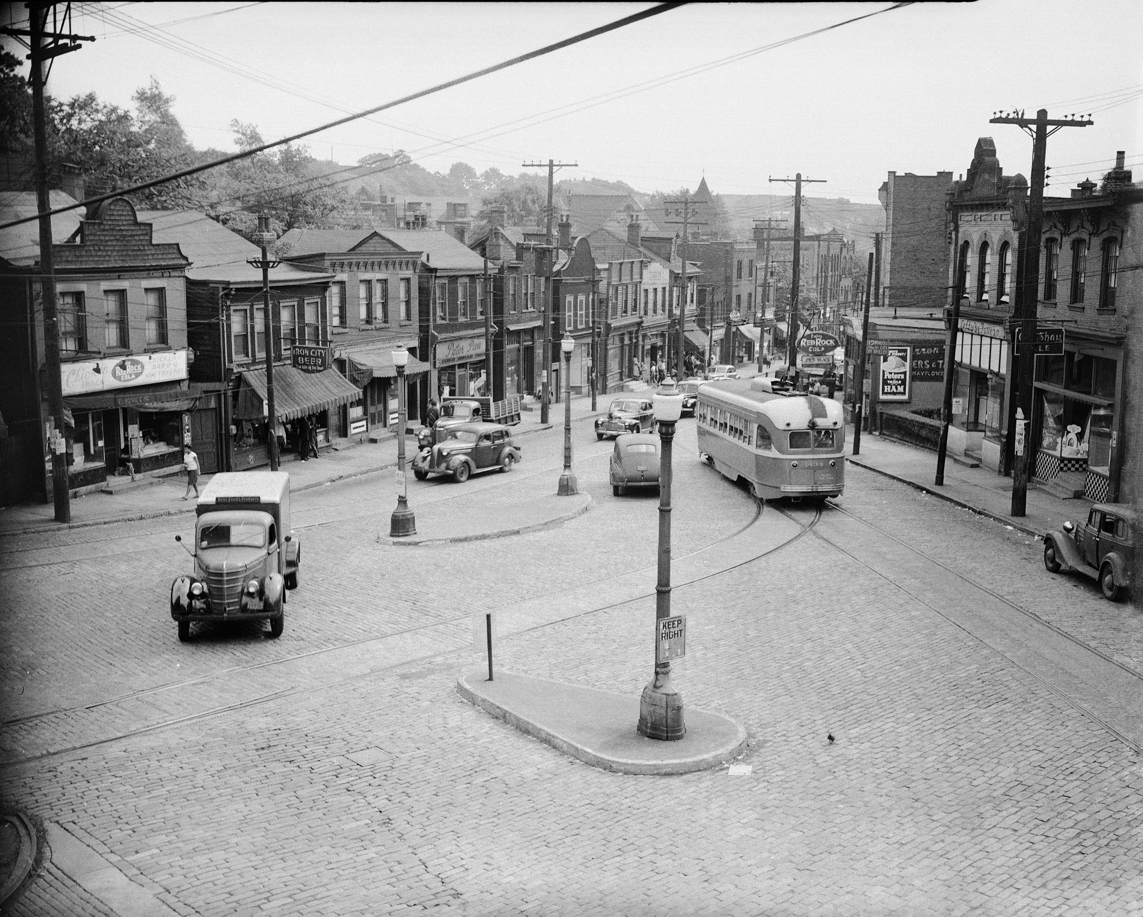 Charles Teenie Harris photo of Herron Avenue at intersection of Milwaukee Street, with Chicken Shack, Peter Pan Shop, and streetcar on right, Hill District