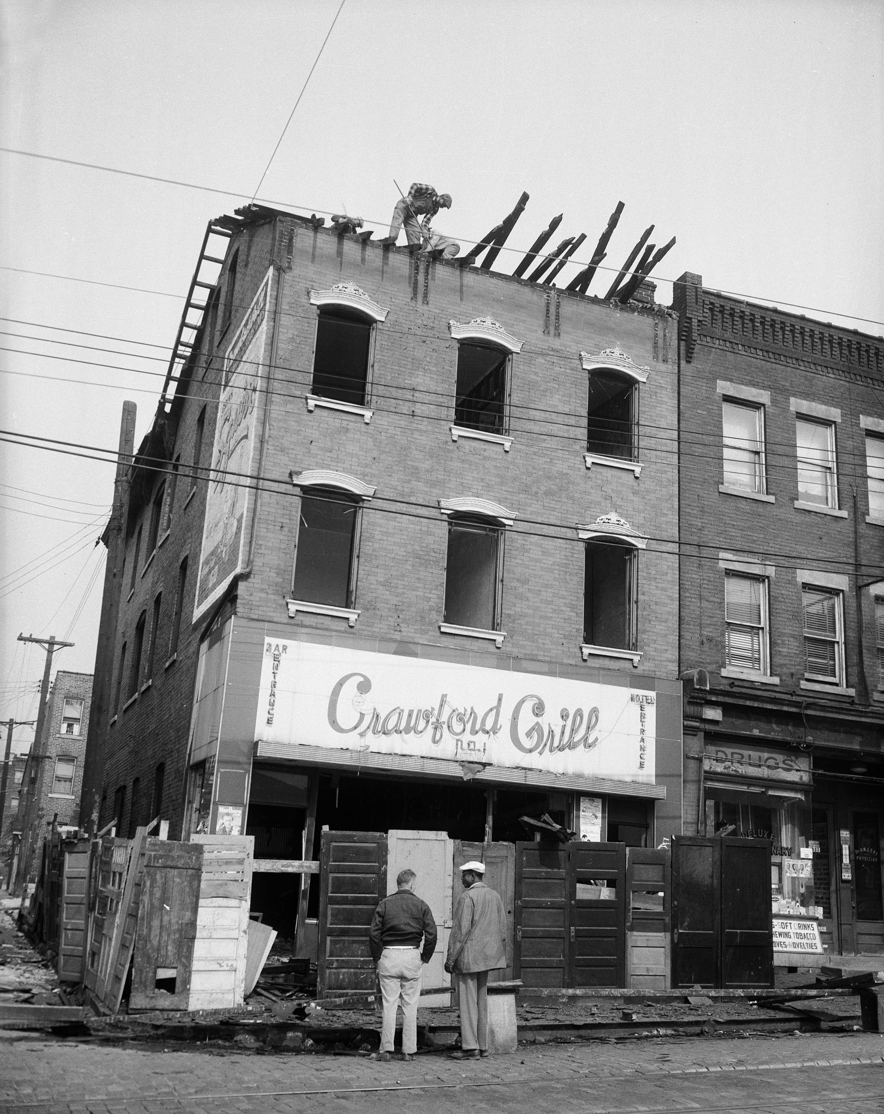 Charles Teenie Harris photo of Workers demolishing roof of Crawford Grill No. 1, Wylie Avenue at Townsend Street, Hill District