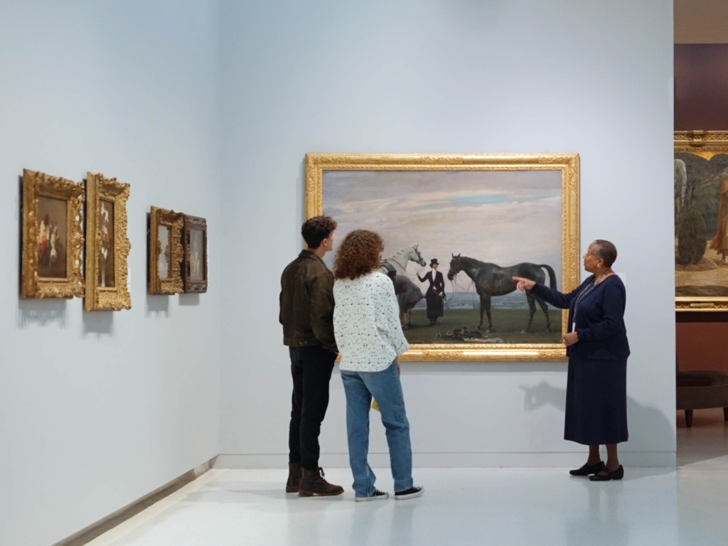 A docent tour in front of a painting.
