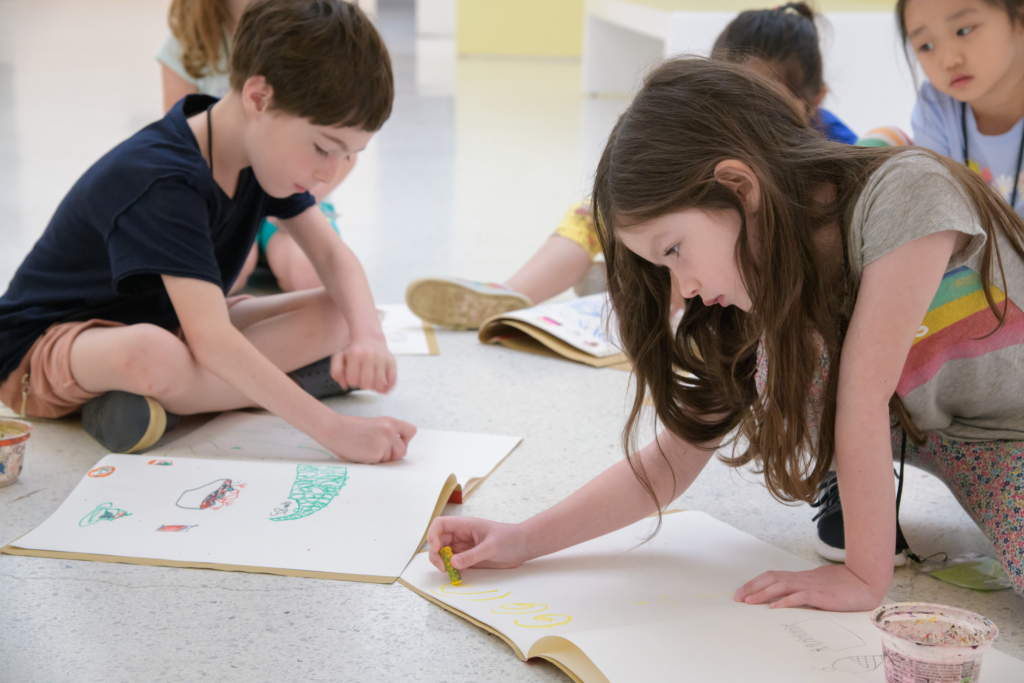 children drawing with crayons at a summer camp event