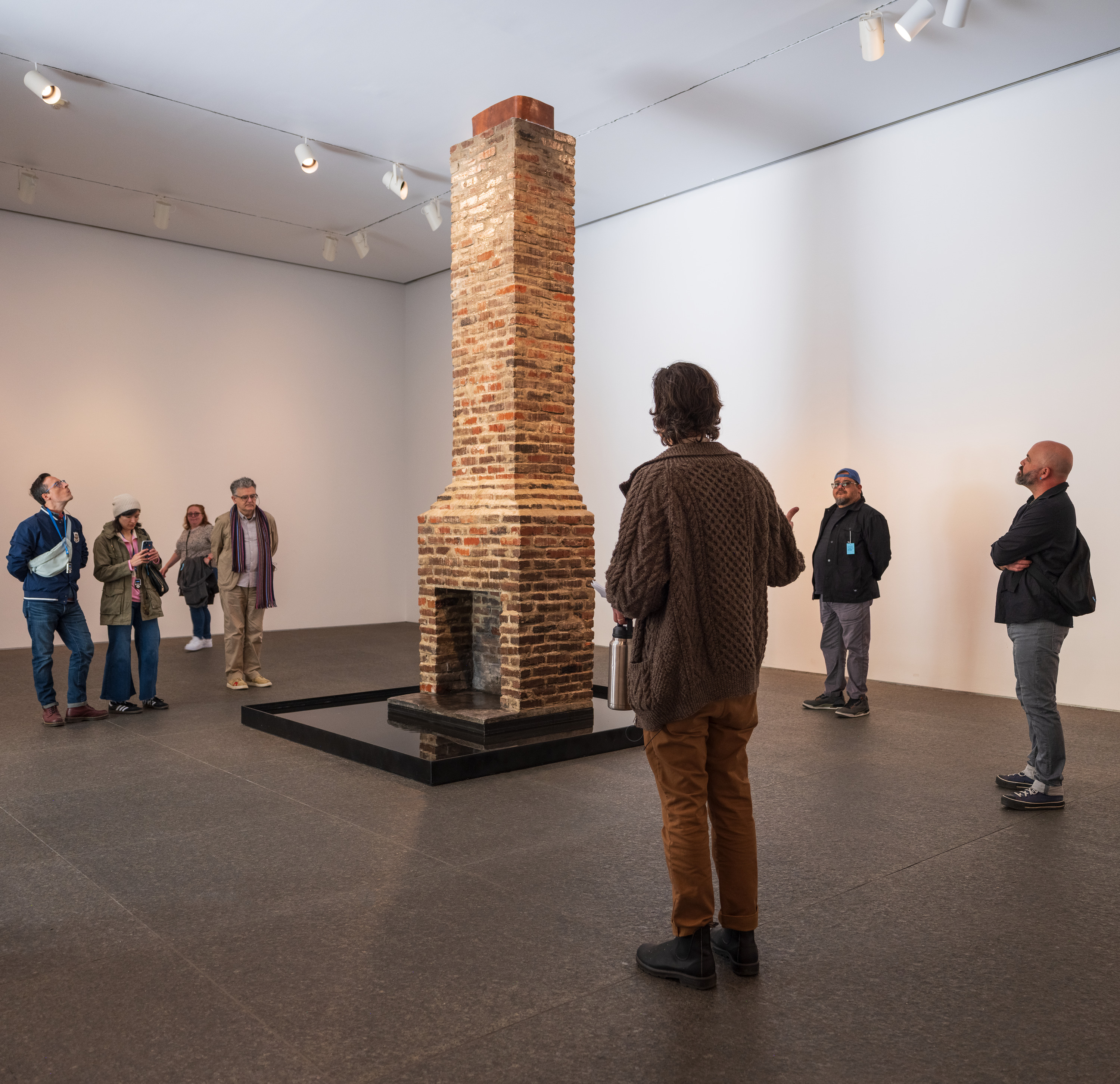 people standing around an chimney fireplace exhibit