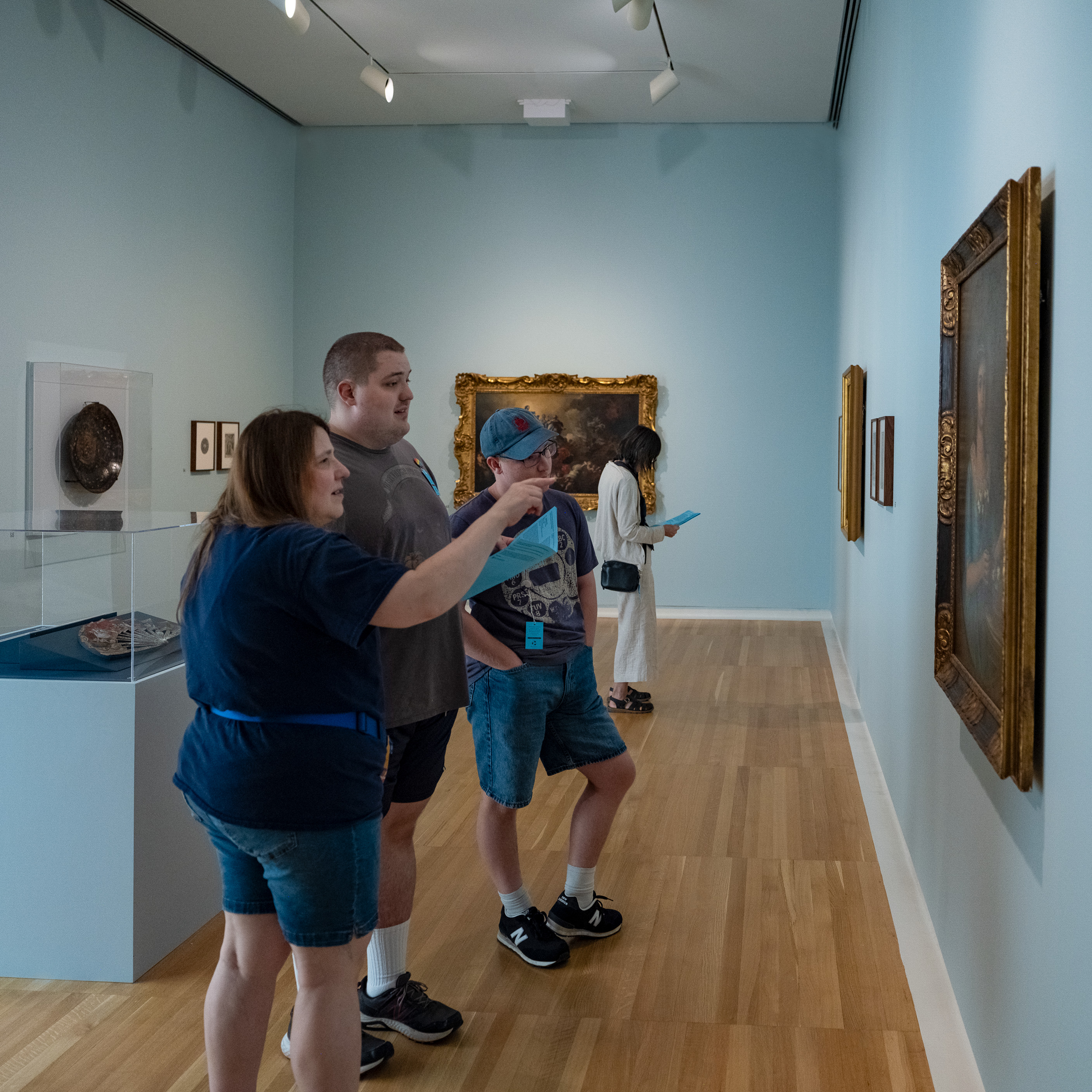 people pointing at paintings
