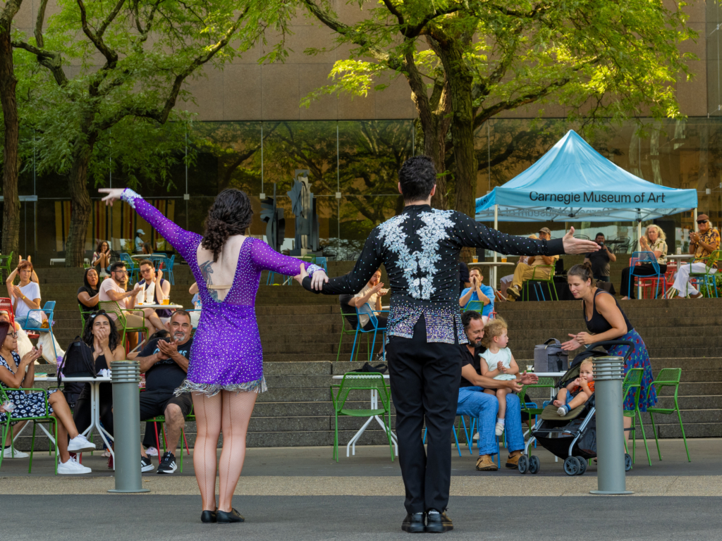 people presenting in the sculpture court at the carnegie museum of art