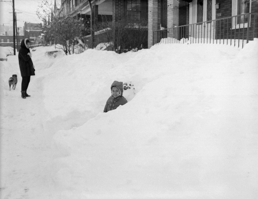 Charles Teenie Harris, Child seated in snow drift in front of house