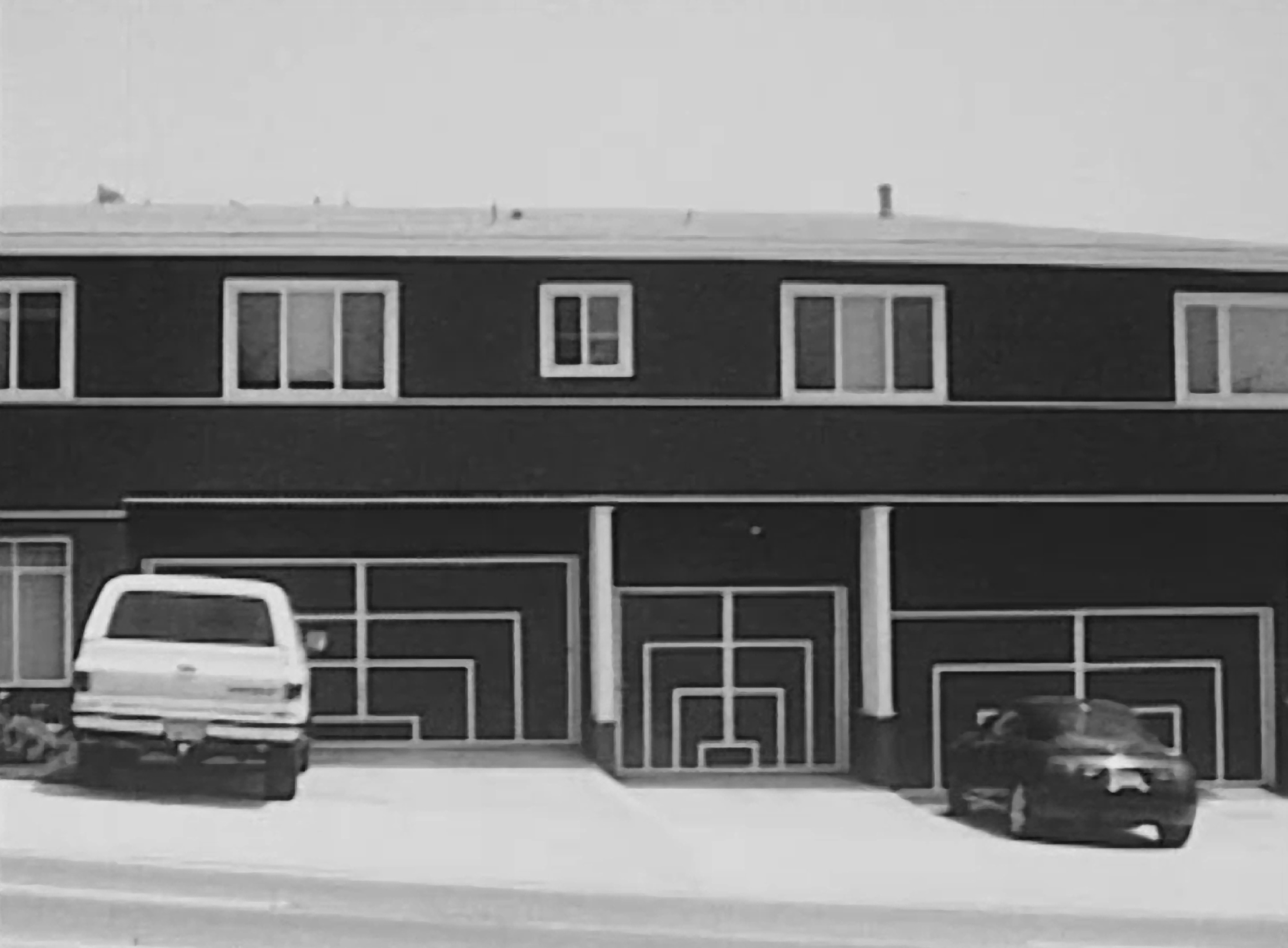 photograph of a building with cars parked outside