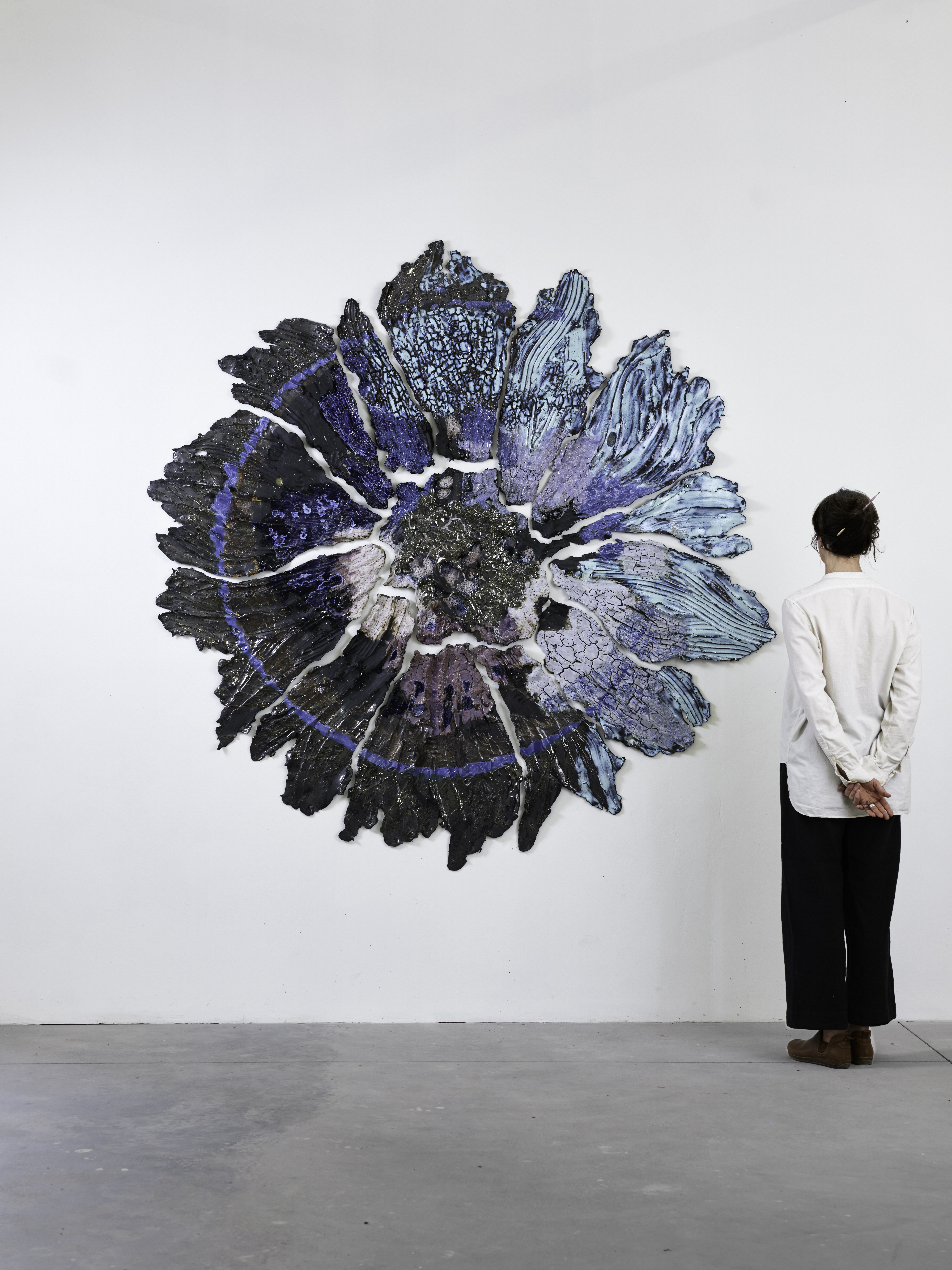person looking at an abstract painting of a flower