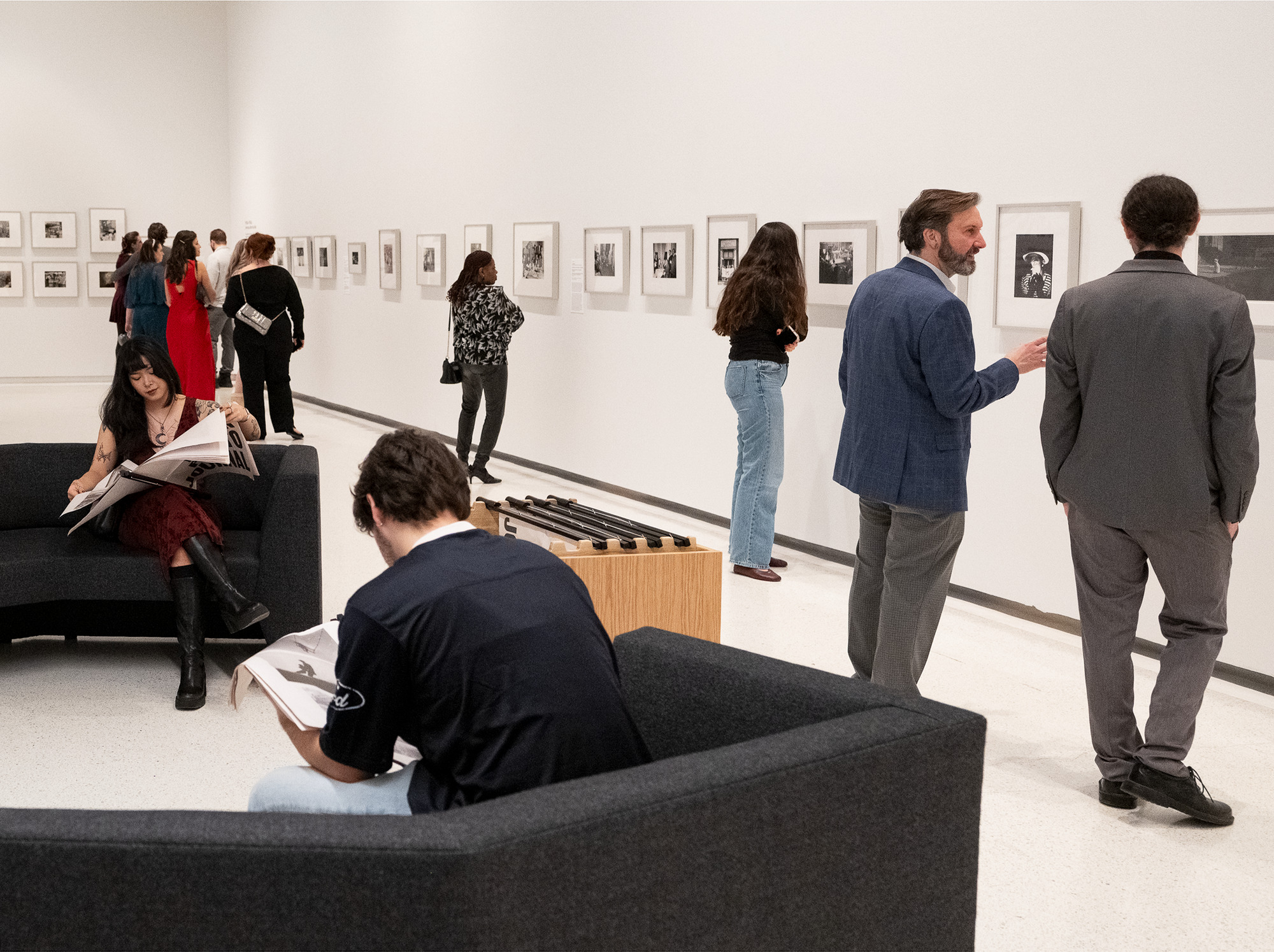 people in the galleries looking at black and white photographs on the wall