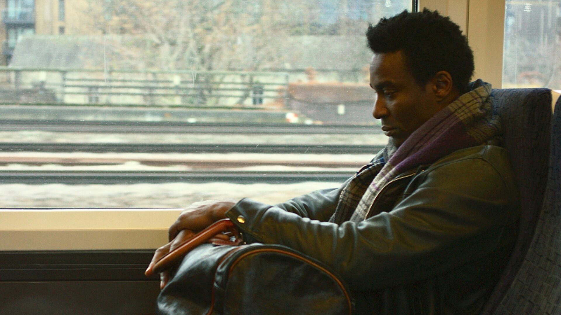 a film still of a man on a train
